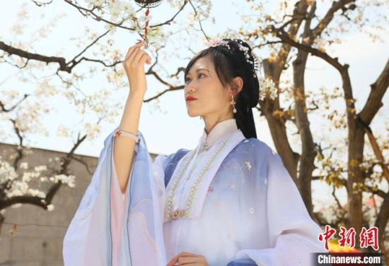 圖為蘭州青年身穿漢服在百年梨園賞景?！「哒?攝