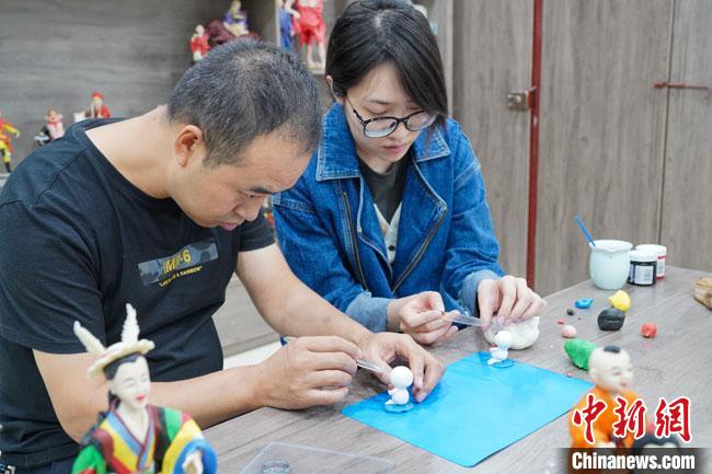 <a target='_blank'  data-cke-saved- >中新社</a>記者(右)現(xiàn)場(chǎng)體驗(yàn)面塑制作過程。　陳爭(zhēng)強(qiáng) 攝