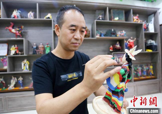 圖為安秋平正在創(chuàng)作代表隴南文縣民俗的《白馬人》作品?！「哒?攝