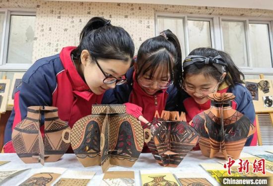 圖為學(xué)生用紙創(chuàng)作的立體彩陶?！⒂裉?攝