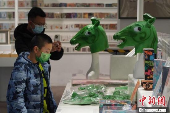 圖為“神馬來了”銅奔馬頭套吸引參觀者駐足?！【琶赖┰?攝