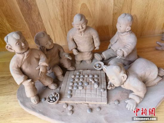 圖為泥塑作品展現(xiàn)下棋場景。 劉玉桃 攝