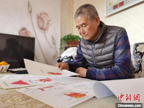 圖為陸鵬飛向記者展示多年帶隊(duì)的手寫筆記?！堟?攝