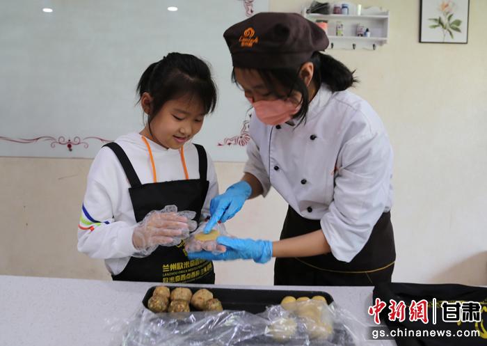 圖為在甘臺胞小朋友在工作人員指導(dǎo)下制作月餅。九美旦增 攝
