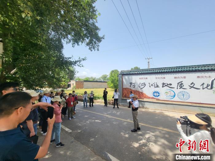 圖為中國(guó)地質(zhì)大學(xué)(北京)教授張緒教介紹村落情況?！『衍?攝