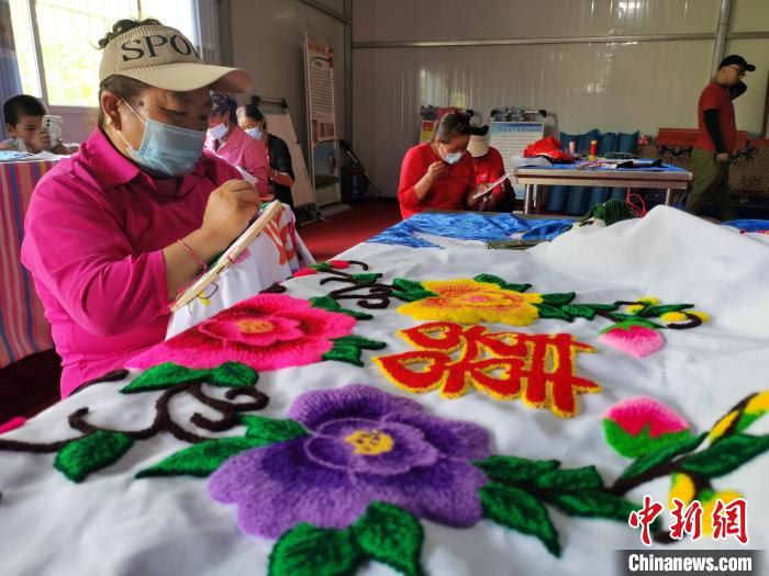圖為婦女制作青繡?！?zhí)砀?攝