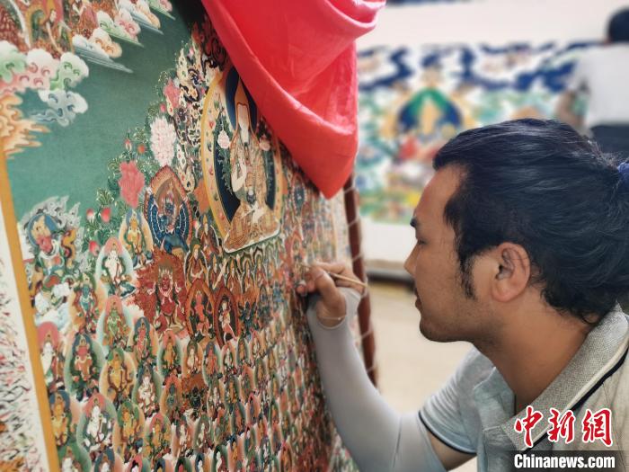 圖為更登才讓的徒弟繪畫唐卡。　張?zhí)砀?攝