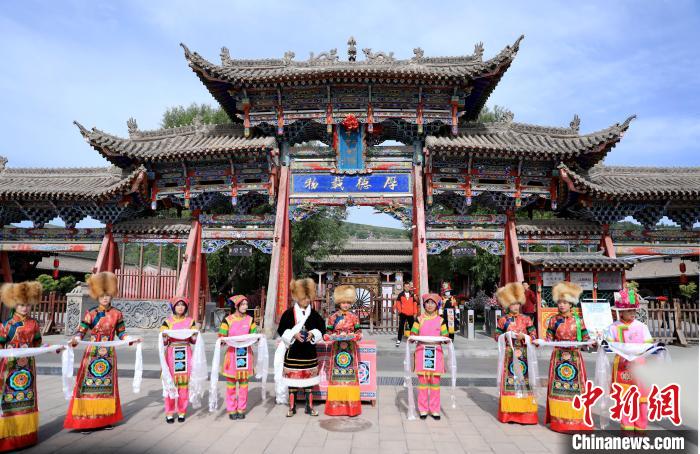 圖為身穿土族服飾的工作人員迎接訪客?！⊙Φ?攝