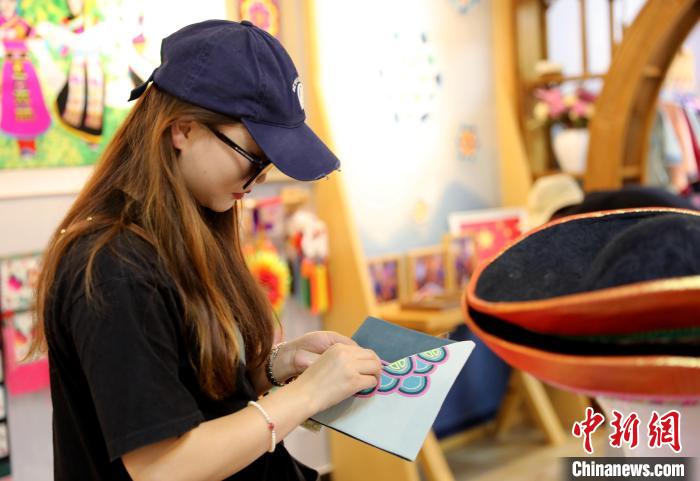 圖為民眾體驗(yàn)國家級(jí)非遺項(xiàng)目盤繡技藝?！⊙Φ?攝