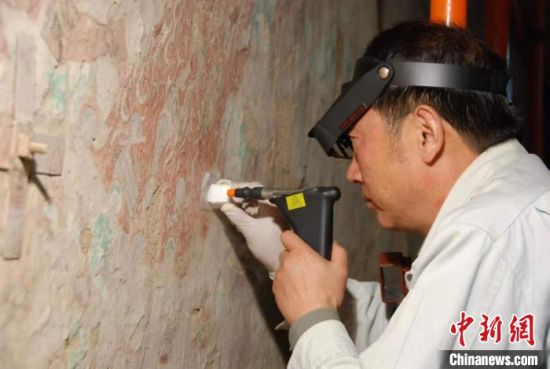 敦煌研究院研究員樊再軒進(jìn)行壁畫(huà)修復(fù)。(資料圖)張?jiān)莆?攝