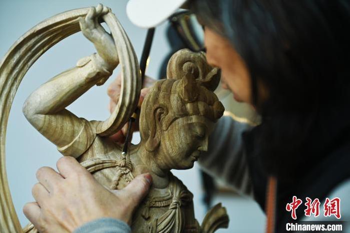 圖為季茂杰進行敦煌元素的木雕創(chuàng)作。李亞龍 攝</p>
<p>