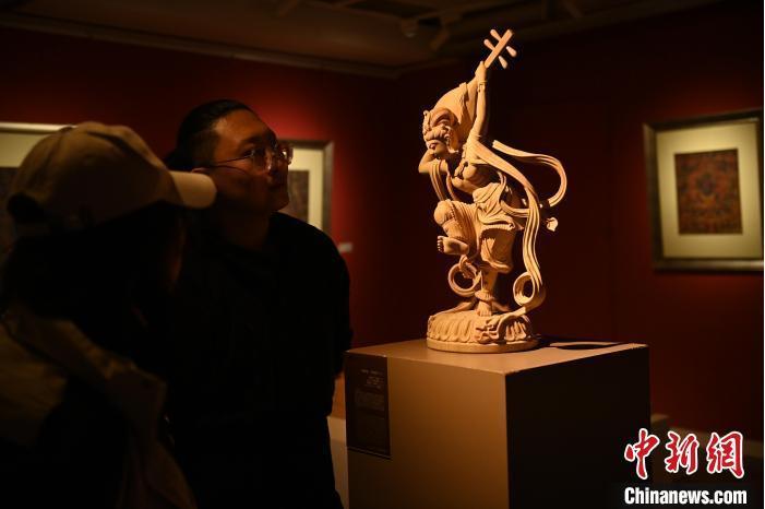 圖為季茂杰向參觀者介紹自己創(chuàng)作敦煌木雕的過程。李亞龍 攝</p>
<p>