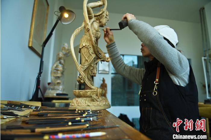 圖為季茂杰進行敦煌元素的木雕創(chuàng)作。李亞龍 攝</p>
<p>