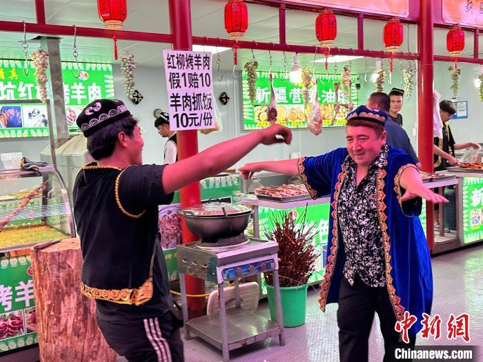 圖為餐飲經(jīng)營者在“西涼不夜城”跳起舞蹈引客?！〈魑牟?攝</p><p>