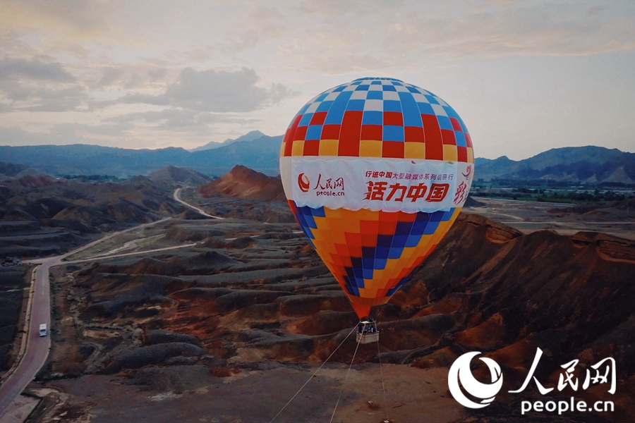 熱氣球在七彩丹霞上升起。人民網 李根攝