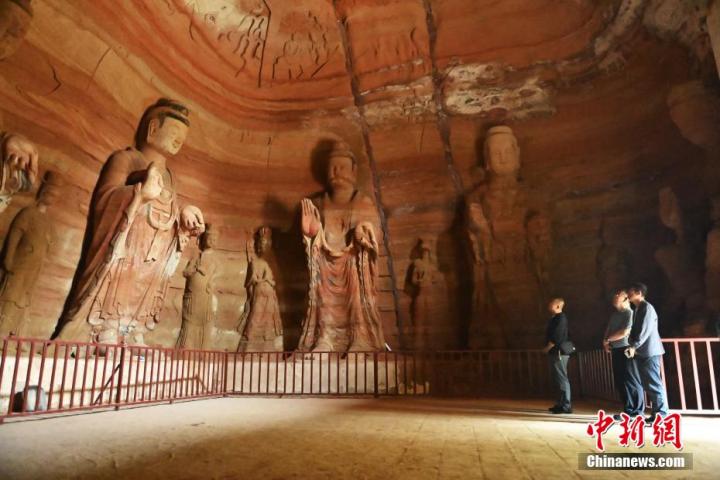 7月15日，游人參觀甘肅省平?jīng)鍪袥艽h百里石窟長廊中的南石窟寺1號窟。百里石窟長廊位于涇川縣境內，由512個石窟、5眼窟中石井組成，現(xiàn)存王母宮石窟、鳳凰山石窟、南石窟寺、丈八寺石窟、羅漢洞石窟、太山寺石窟等規(guī)模較大的石窟群，還有數(shù)量眾多的小石窟群。南石窟寺開鑿于北魏永平三年，其中1號窟屬于大型七佛窟，七佛高達6米。中新社記者 李亞龍 攝