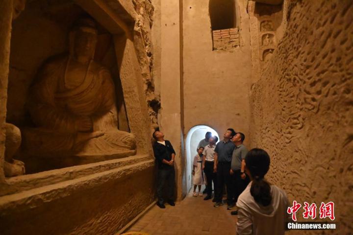 7月15日，游人參觀甘肅省平?jīng)鍪袥艽h百里石窟長廊中的王母宮石窟。百里石窟長廊位于涇川縣境內，由512個石窟、5眼窟中石井組成，現(xiàn)存王母宮石窟、鳳凰山石窟、南石窟寺、丈八寺石窟、羅漢洞石窟、太山寺石窟等規(guī)模較大的石窟群，還有數(shù)量眾多的小石窟群。王母宮石窟又名千佛洞，該窟設計宏大，造像生動，窟內擁有造像數(shù)百尊，是較為珍貴的佛教文化歷史遺存。中新社記者 李亞龍 攝</p>
<p>