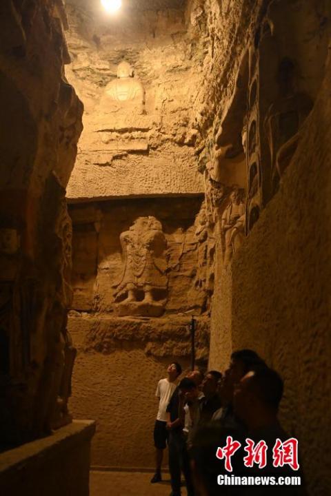 7月15日，游人參觀甘肅省平?jīng)鍪袥艽h百里石窟長廊中的王母宮石窟。百里石窟長廊位于涇川縣境內，由512個石窟、5眼窟中石井組成，現(xiàn)存王母宮石窟、鳳凰山石窟、南石窟寺、丈八寺石窟、羅漢洞石窟、太山寺石窟等規(guī)模較大的石窟群，還有數(shù)量眾多的小石窟群。王母宮石窟又名千佛洞，該窟設計宏大，造像生動，窟內擁有造像數(shù)百尊，是較為珍貴的佛教文化遺存。中新社記者 李亞龍 攝</p>
<p>