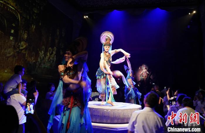 《樂動敦煌》是全球首部洞窟式沉浸體驗劇，利用真人與數(shù)字影像虛實交換實現(xiàn)沉浸式體驗。圖為2023年8月28日晚，《樂動敦煌》演出。(資料圖)中新社記者 毛建軍 攝